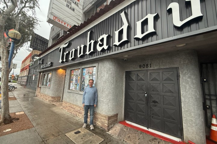 Person standing outside the Troubadour venue on a rainy day.