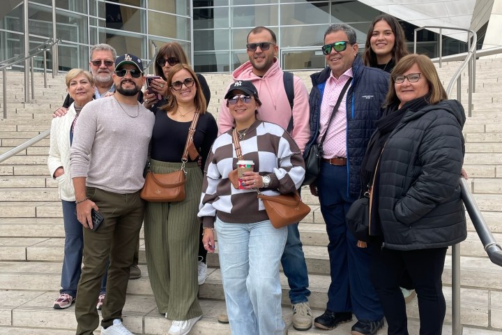 Group of people posing on steps outside a modern building.