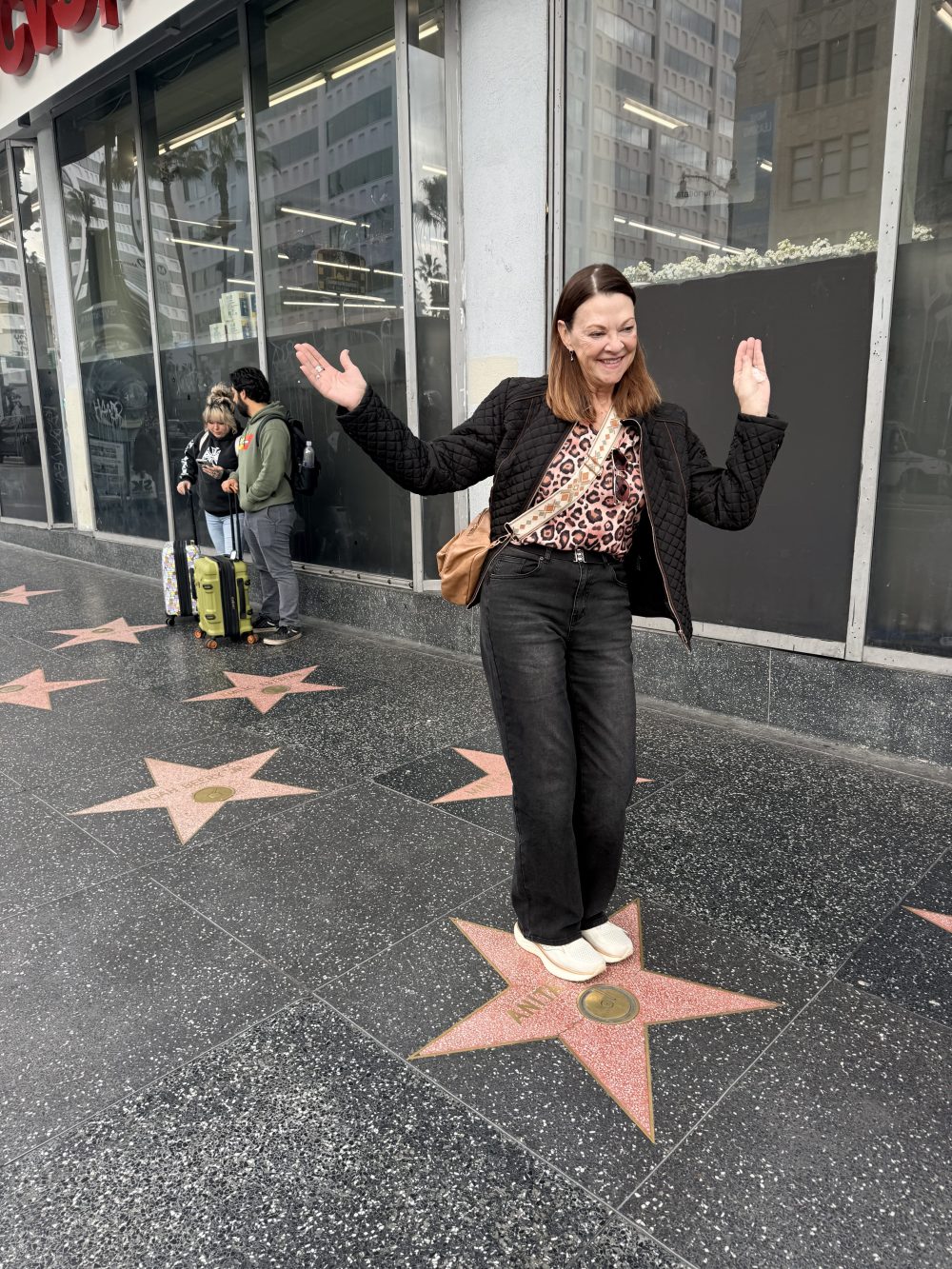 Visitor celebrating on a star along the Hollywood Walk of Fame