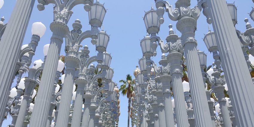 Rows of tall, ornate street lamps under a clear blue sky.