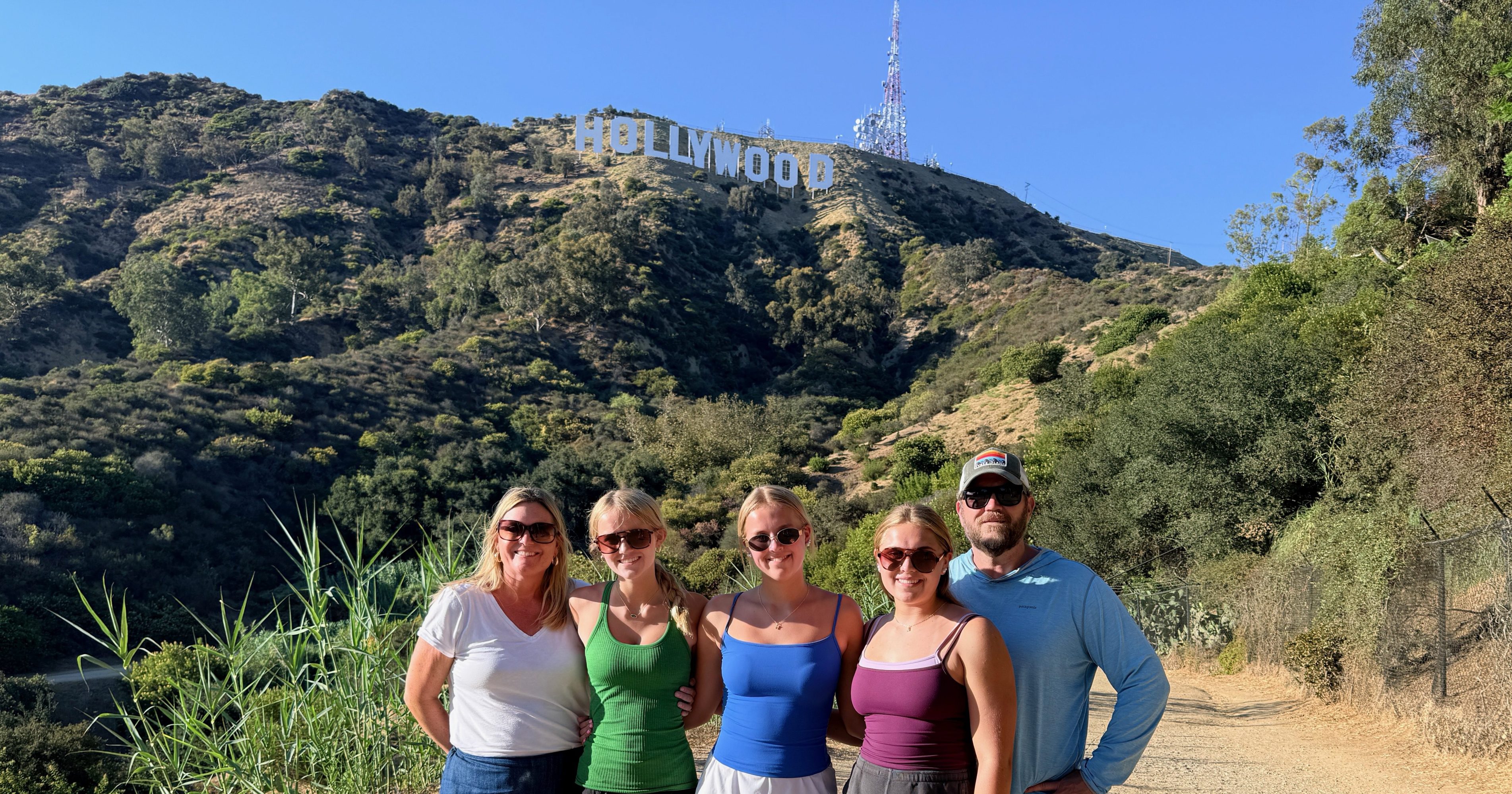 Family of five below the Hollywood Sign on the Innsdale Trail during a Guideline Tours private tour