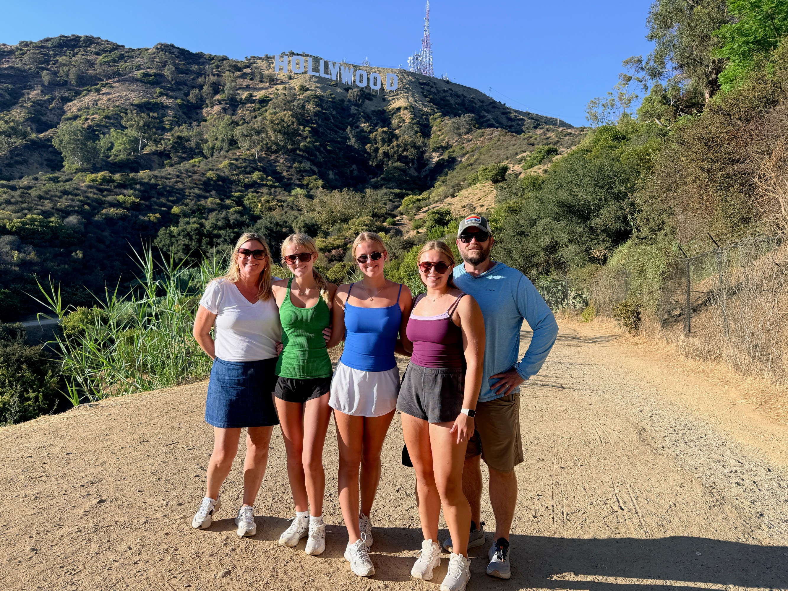 Family of five below the Hollywood Sign on the Innsdale Trail during a Guideline Tours private tour